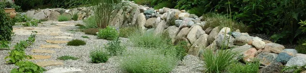 Rock garden laid out with boulders, gravel and ornamental grasses