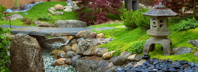Stone lantern, stone bridge and pebble streambed in an oriental garden